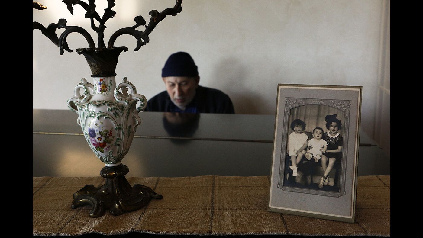 Bernard sits at the piano, which holds a photo of Ileene, left, her brother Robert and sister Irene Martin taken in 1936 in El Paso, Texas.