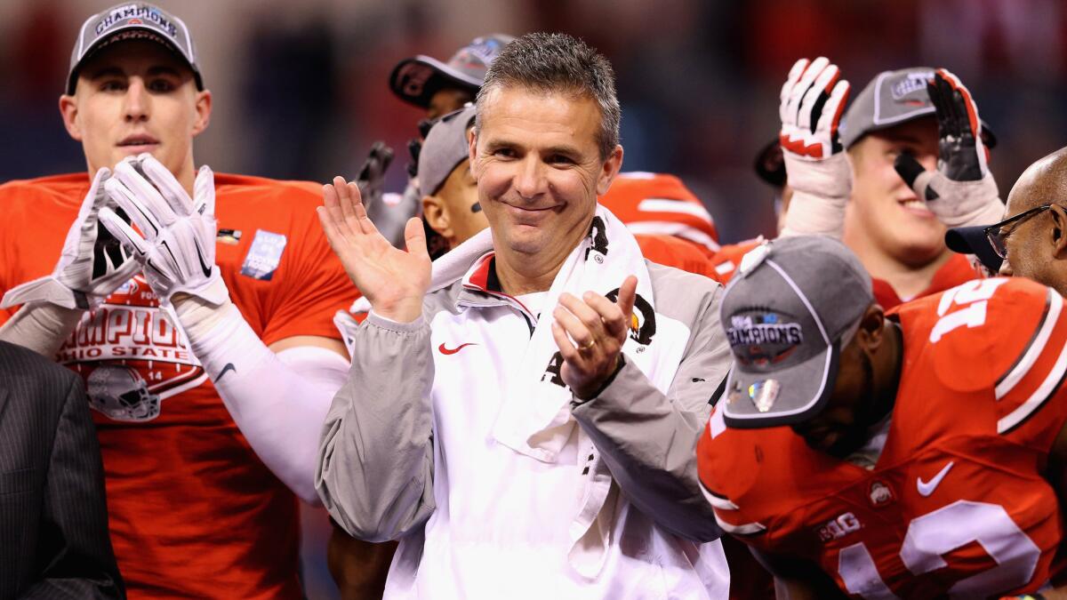 Ohio State Coach Urban Meyer celebrates with his players after a 59-0 win over Wisconsin in the Big Ten championship game in Indianapolis on Saturday.
