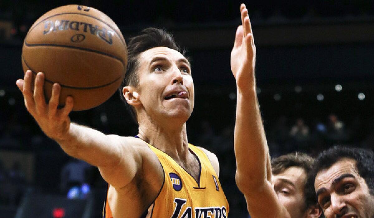 Steve Nash drives past Hamed Haddadi and Goran Dragic during a Lakers game against the Phoenix Suns in March 2013.