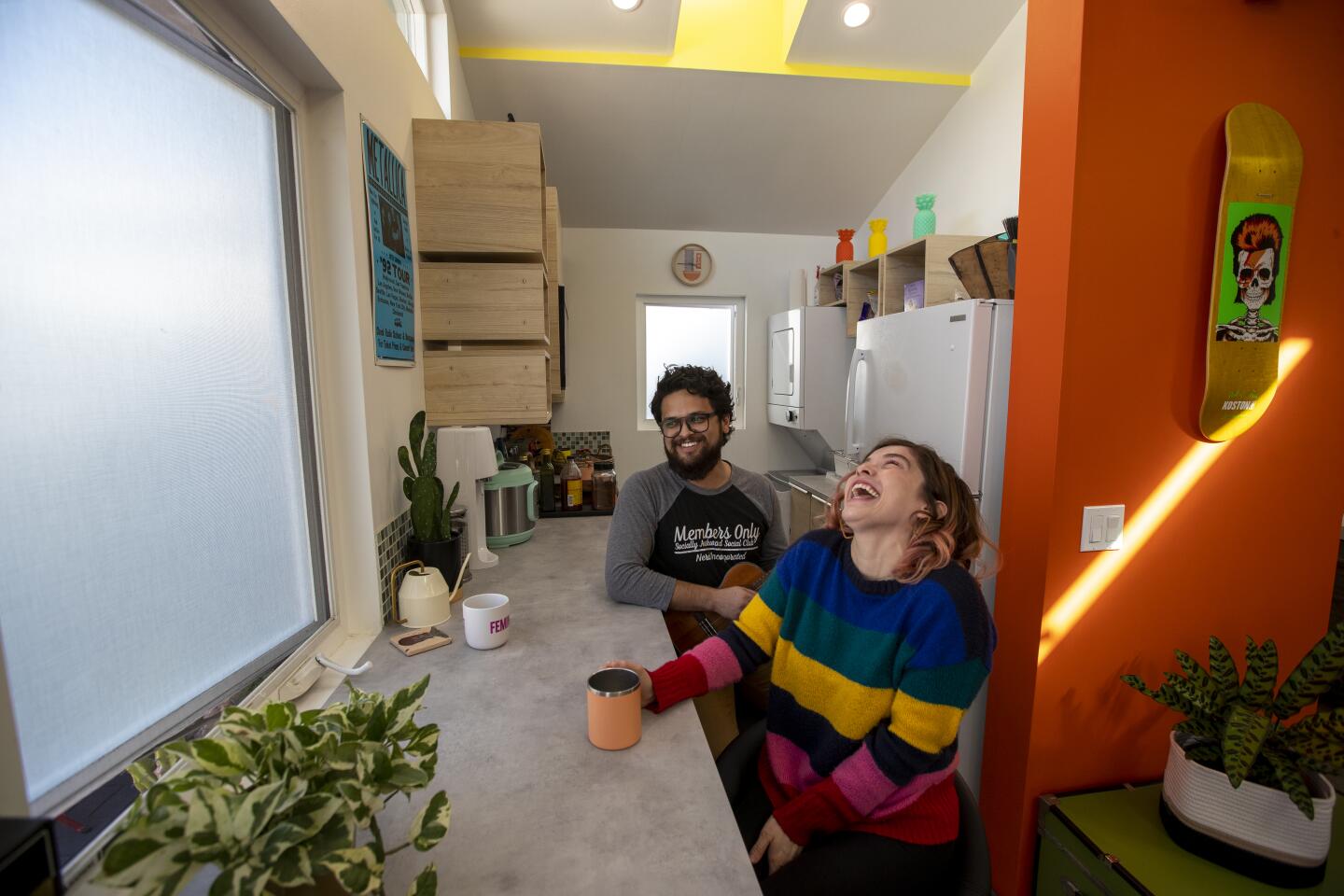 A man and woman sit at the kitchen counter.