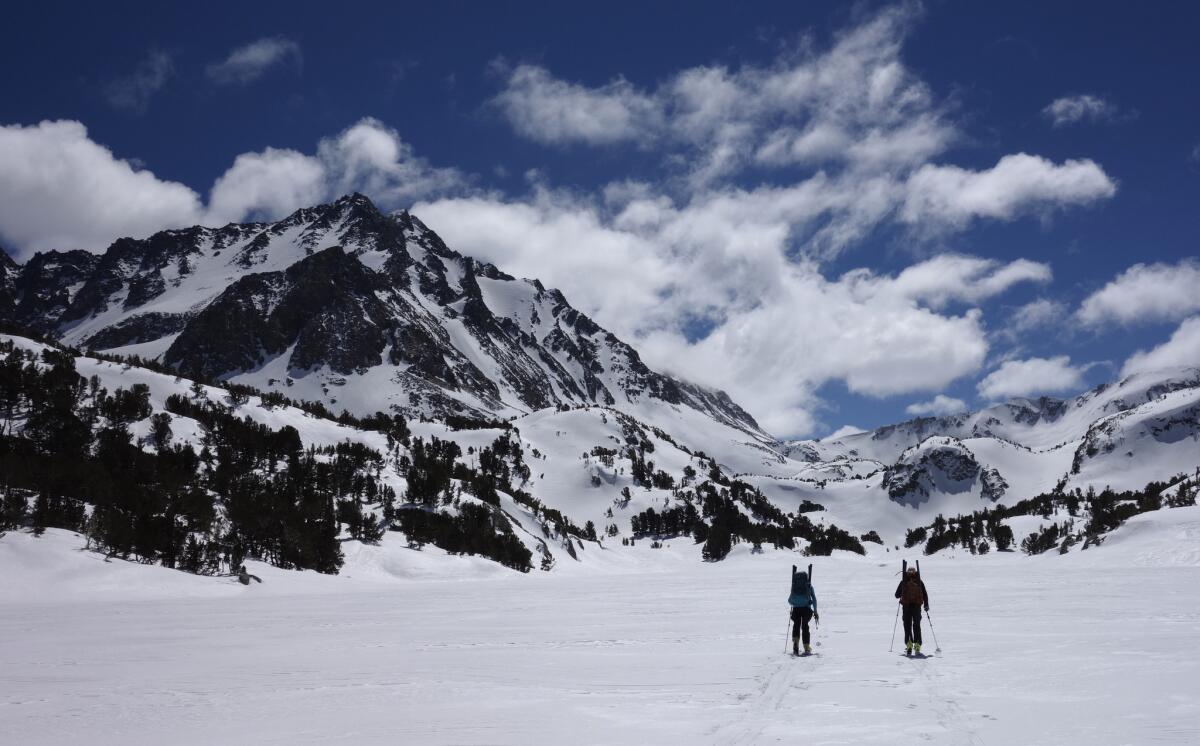 Ann Klinefelter, left, and her husband, Kevin Klinefelter, ski across a frozen lake during a California Cooperative Snow Survey in the Inyo National Forest near Bishop, Calif., on March 31.