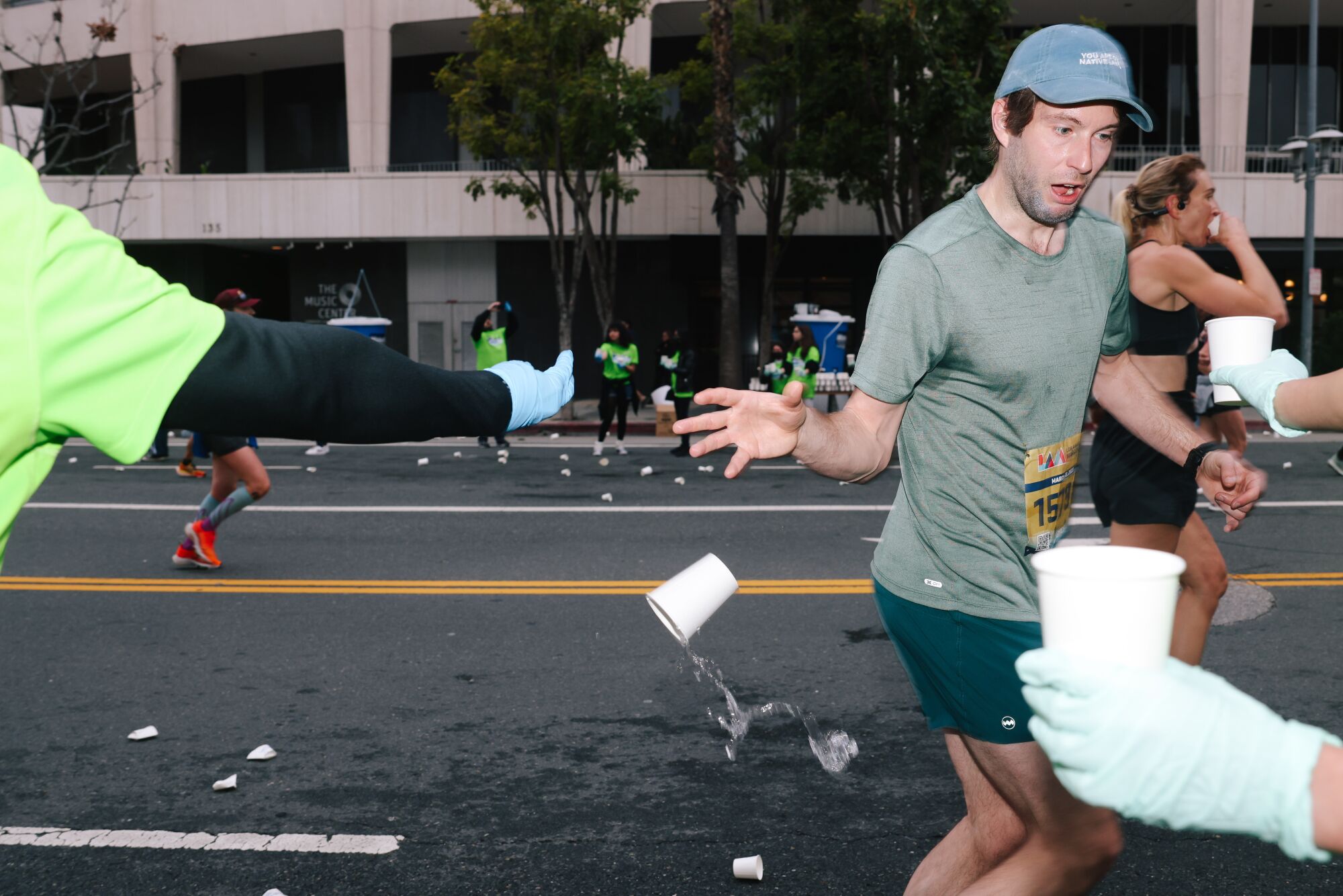 A runner drops a cup of water while passing through downtown during the 38th Los Angeles Marathon.