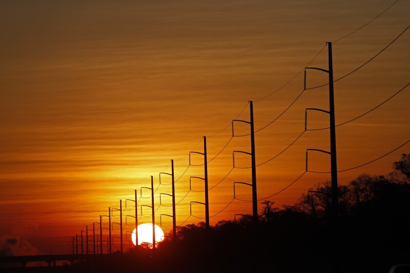 In this Jan. 31, 2018, file photo, the sun rises beyond power lines in St. Charles Parish, La. Homeland Security officials say that Russian hackers used conventional tools to trick victims into entering passwords in order to build out a sophisticated effort to gain access to control rooms of utilities in the U.S. The victims included hundreds of vendors that had links to nuclear plants and the electrical grid.