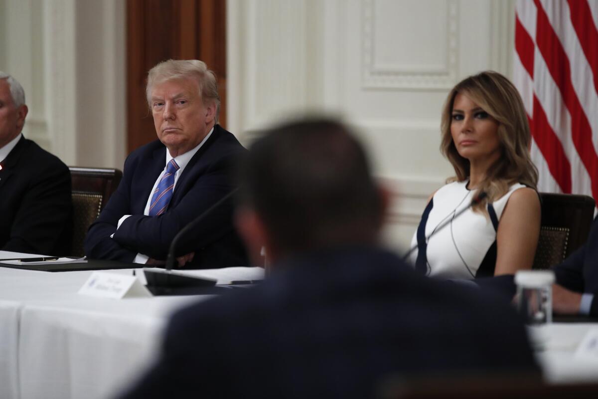 President Trump and First Lady Melania Trump listen during a meeting 