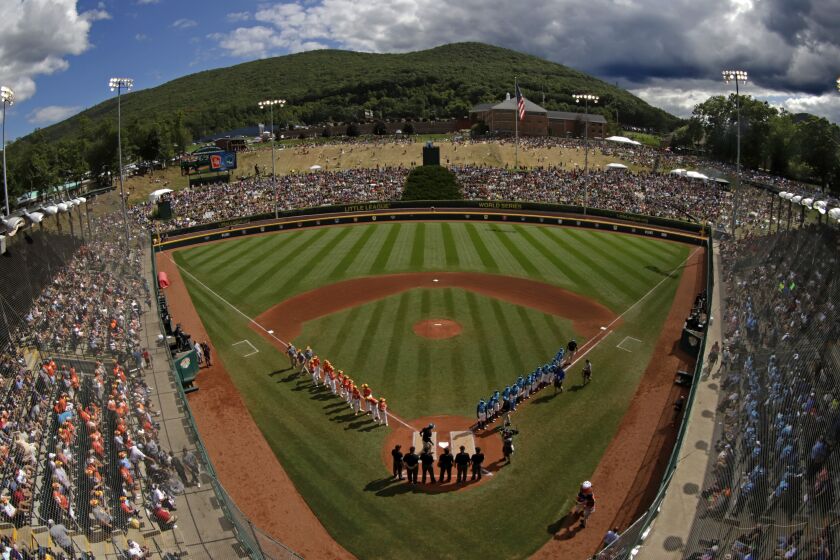 FILE - River Ridge, Louisiana, lines the third baseline and Curacao lines the first baseline during team introductions before the Little League World Series Championship game at Lamade Stadium in South Williamsport, Pa., Sunday, Aug. 25, 2019. The Little League World Series is back. There won’t be international teams or 22,000 fans in the stands for the championship, but the tournament in South Williamsport, Pennsylvania, is set to start on Thursday, Aug. 19, 2021. (AP Photo/Gene J. Puskar)