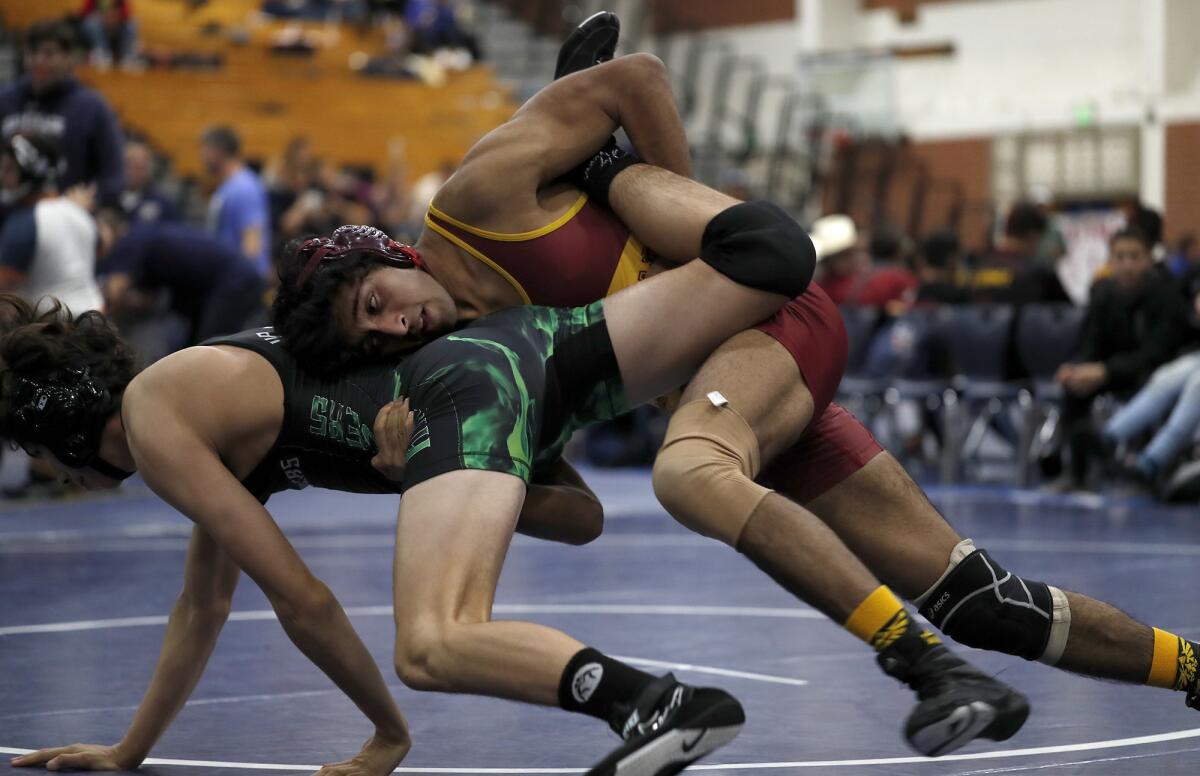 La Cañada High Jaitra Menon, top, competes against Upland in a 138-pound match during the first round of the CIF Southern Section Dual Meet Wrestling Championships at Fountain Valley High on Saturday.