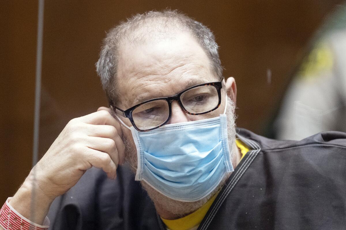 El ex productor cinematográfico y violador convicto Harvey Weinstein, de 69 años, usa un cubrebocas detrás de un acrílico.