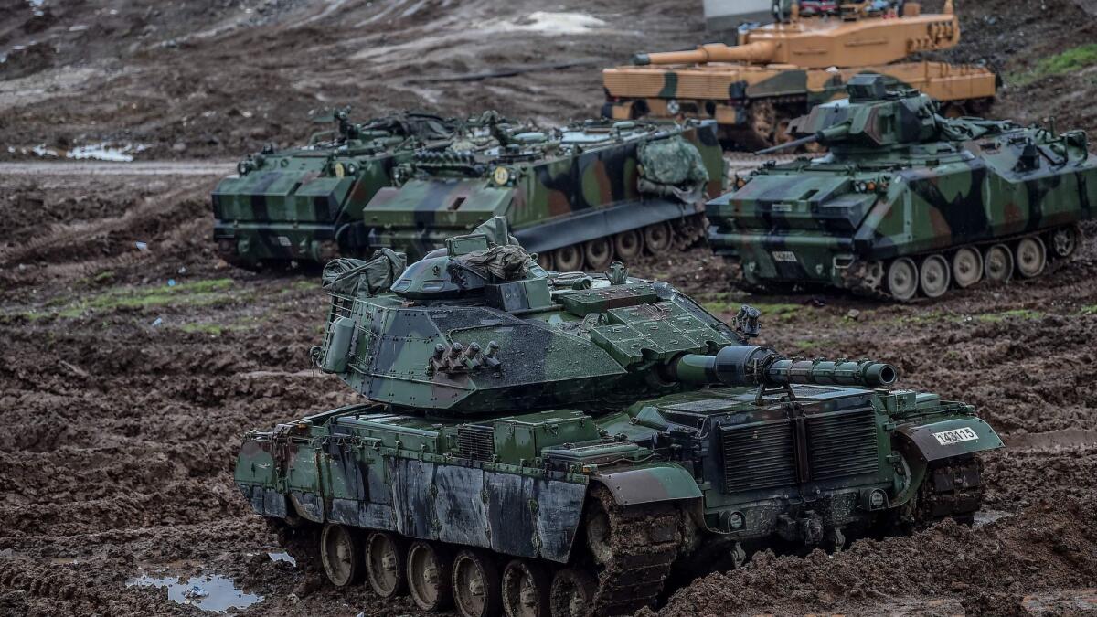 Turkish army tanks are stationed in a field near the Syrian border at Hassa, in Hatay province, on Jan. 25, 2018, as part of a military offensive dubbed "Operation Olive Branch."