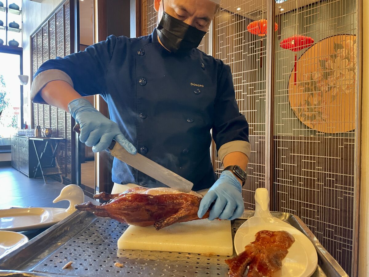 Meizhou roast duck is carved tableside at Meizhou Dongpo in Arcadia.