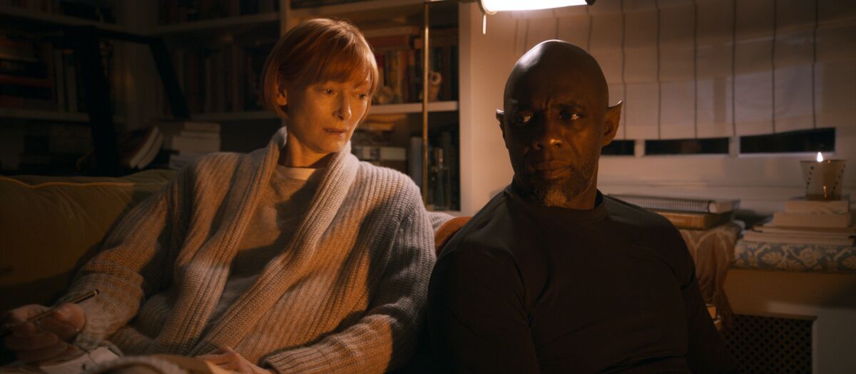 Tilda Swinton and Idris Elba  sit shoulder to shoulder in a scene from "Three Thousand Years of Longing."