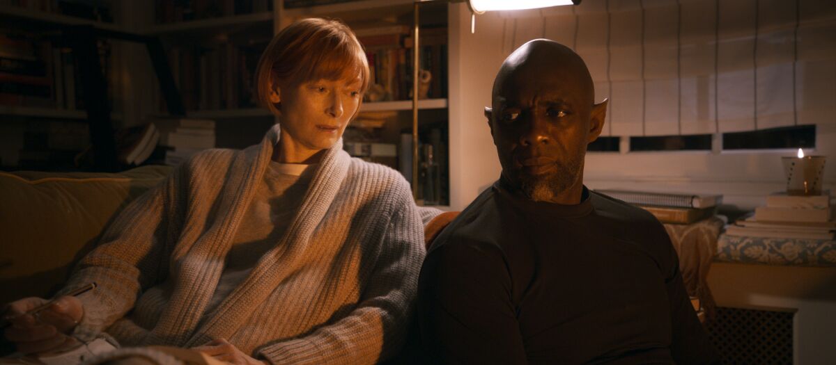 Tilda Swinton and Idris Elba sit shoulder to shoulder in a scene from "Three Thousand Years of Longing."