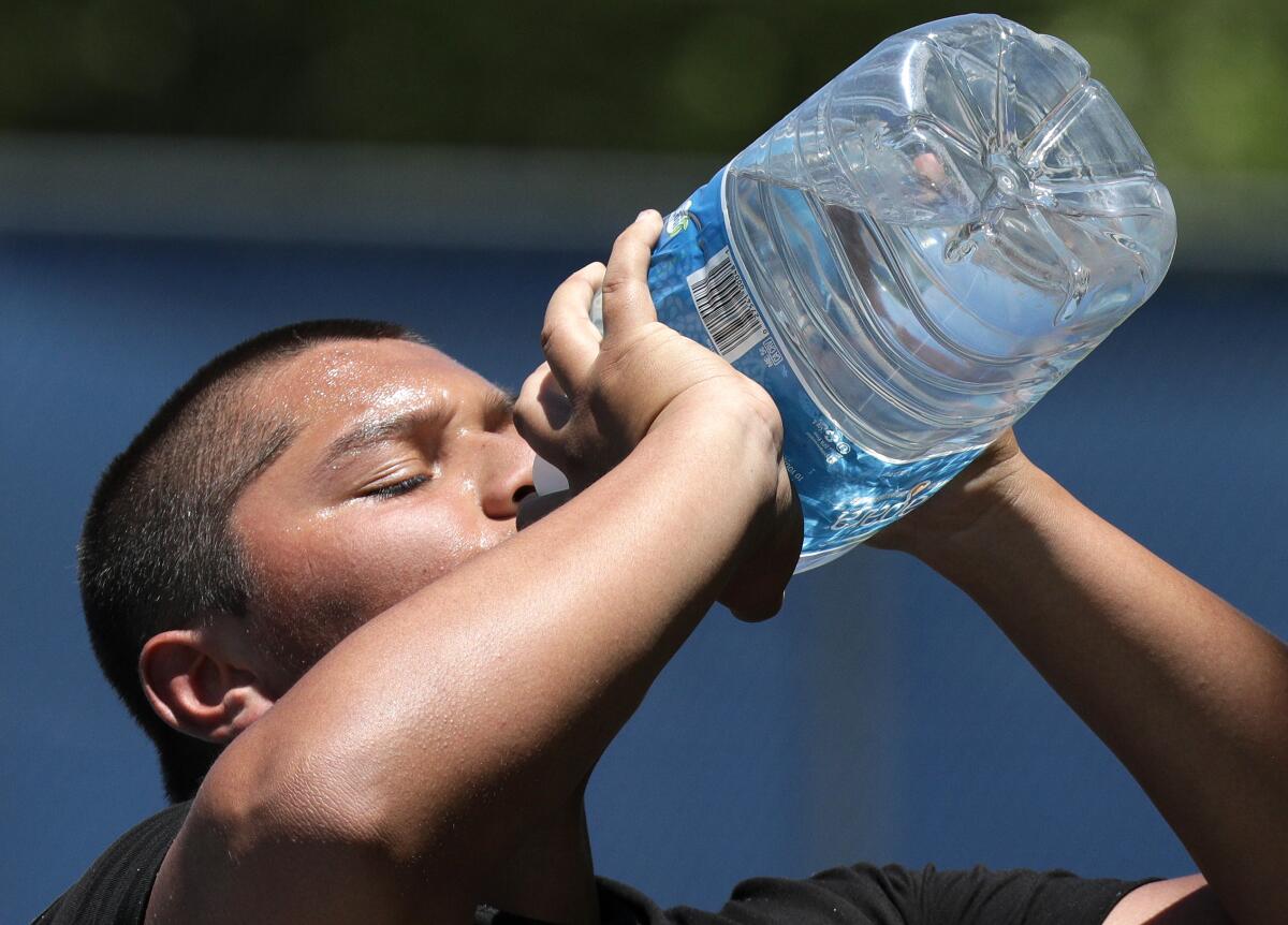 Jovanny Luis, 18, takes a water break while playing basketball with friends Tuesday at Sgt. Steve Owen Memorial Park in Lancaster.