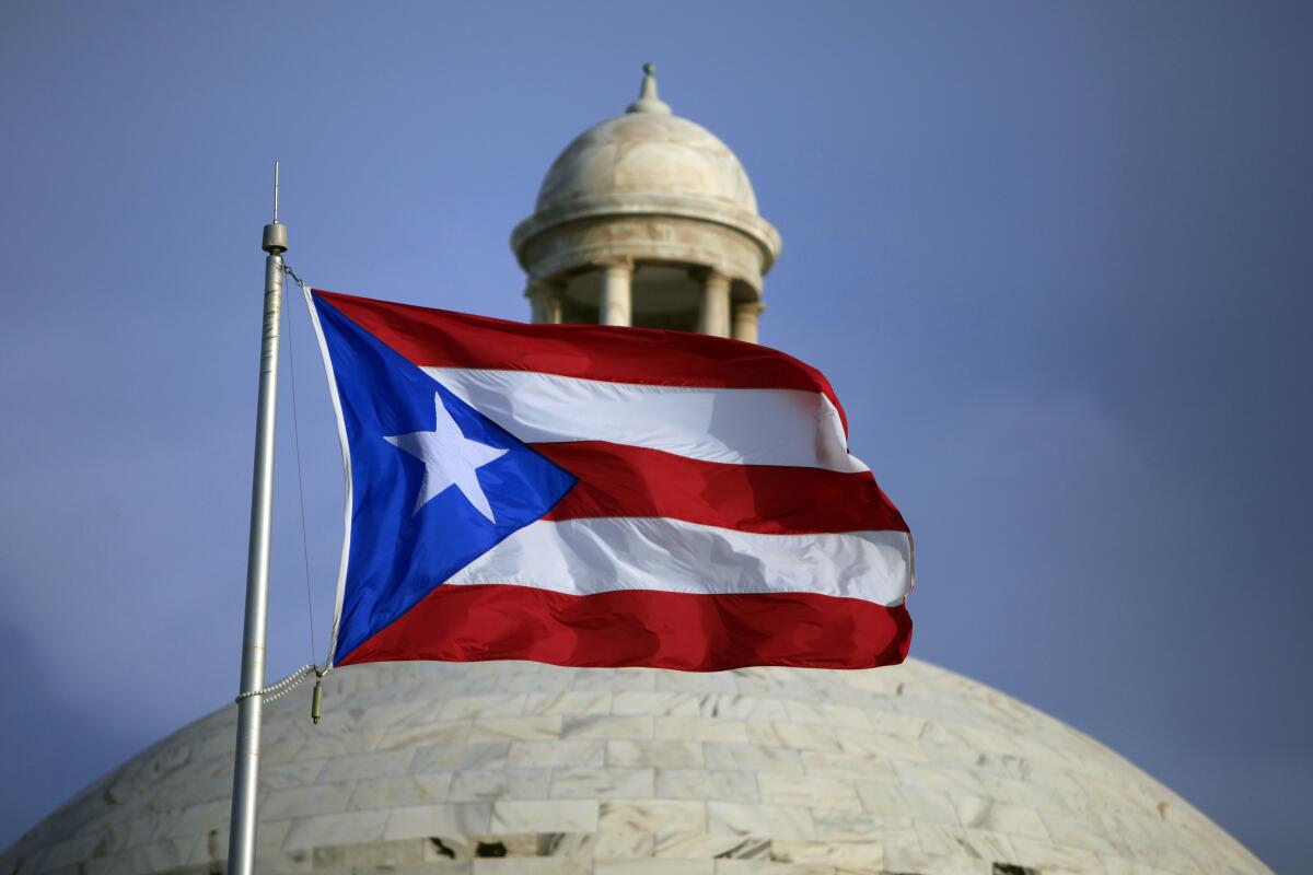 ARCHIVO - La bandera puertorriqueña ondea delante del Capitolio el 29 de julio de 2015, en San Juan, 