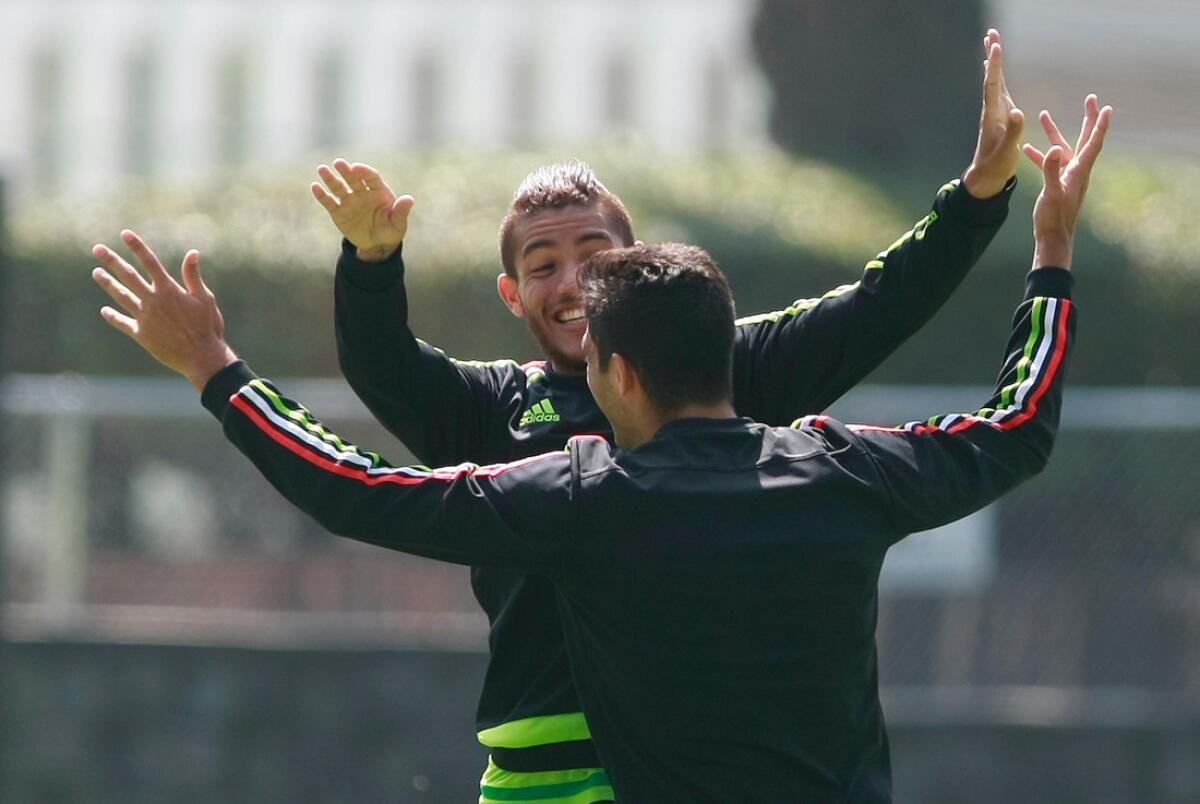El jugador de México, Jonathan Dos Santos, atrás, festeja con su compañero Raúl Jiménez, de espalda, durante un entrenamiento en Ciudad de México.