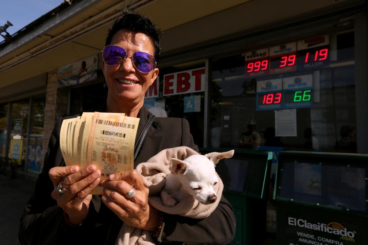 Realtor Alicia Sanchez holds her dog Kiki and $200 worth of Powerball lottery tickets.