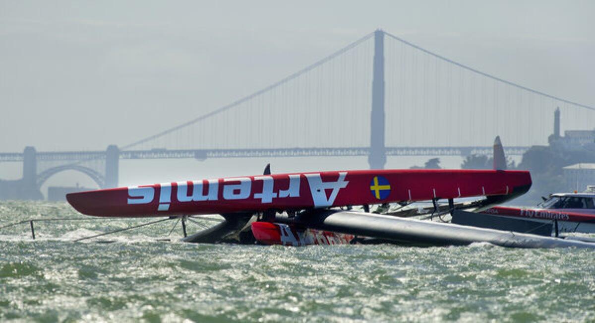 The Artemis Racing AC72 catamaran, an America's Cup entry from Sweden, lies capsized after overturning during training in San Francisco Bay.