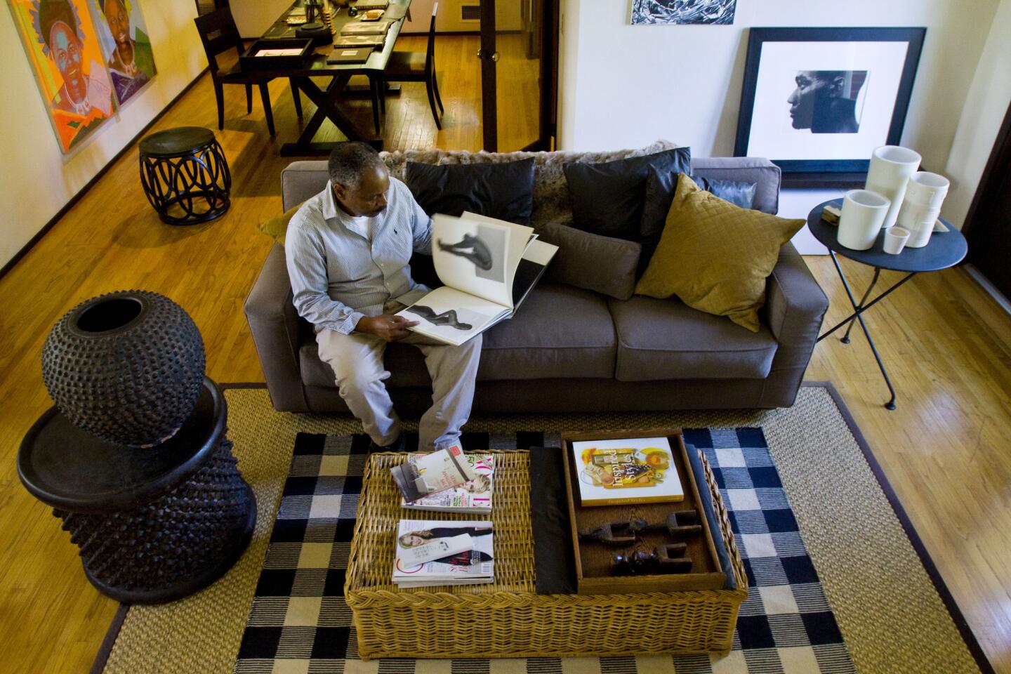 Herrington flips through one of the black-and-white photography books in his living room. The designer likes the graphic punch of black and white and uses that color scheme to provide continuity from room to room. To achieve the minimalist, global look he desired, Herrington combined a well-chosen mix of Euro-style and classic-line contemporary furnishings with ethnic pieces. A Christian Liaigre dining table and chairs stand in the background; an array of natural baskets and a Kreiss rattan bench-turned-coffee table add texture to the room; while a Ralph Lauren Buffalo check rug set atop a bound sisal carpet and hardwood floors add warmth and graphic drama. Note the spiked objects on the left and the white ceramics on the right, which are detailed in the photos to follow.