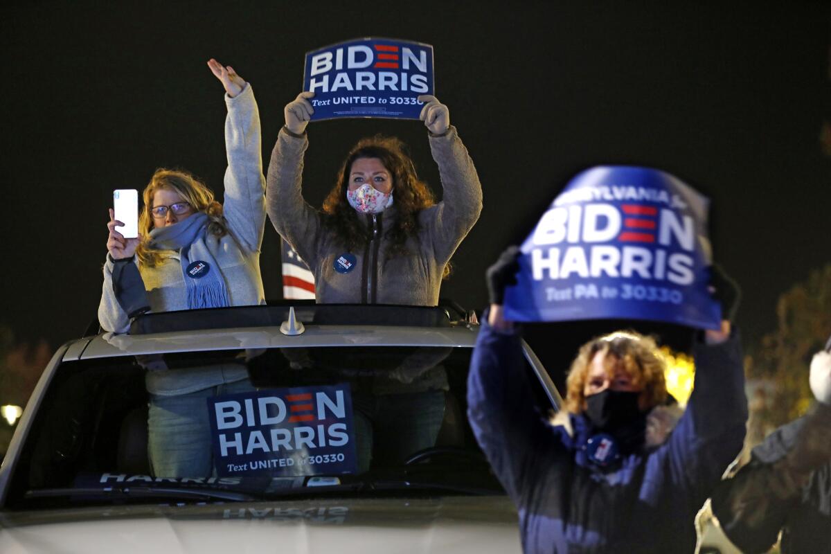 Supporters hold up Biden-Harris signs at the Philadelphia drive-in rally on election eve 