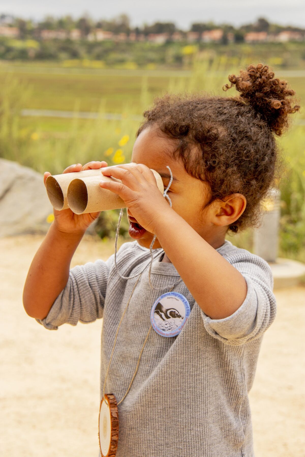 Lyam Allah looks for winged wildlife through cardboard binoculars during April's "Earth Day at the Bay" festivities at the Peter and Mary Muth Interpretive Center in Newport Beach.