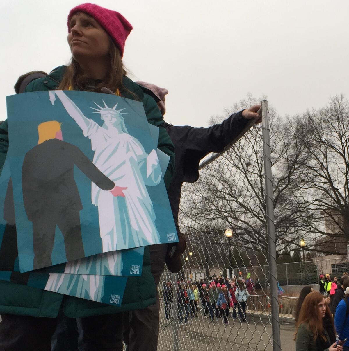 A protestor at the Women's March on Washington holds posters by German illustrator Lennart Gabel.