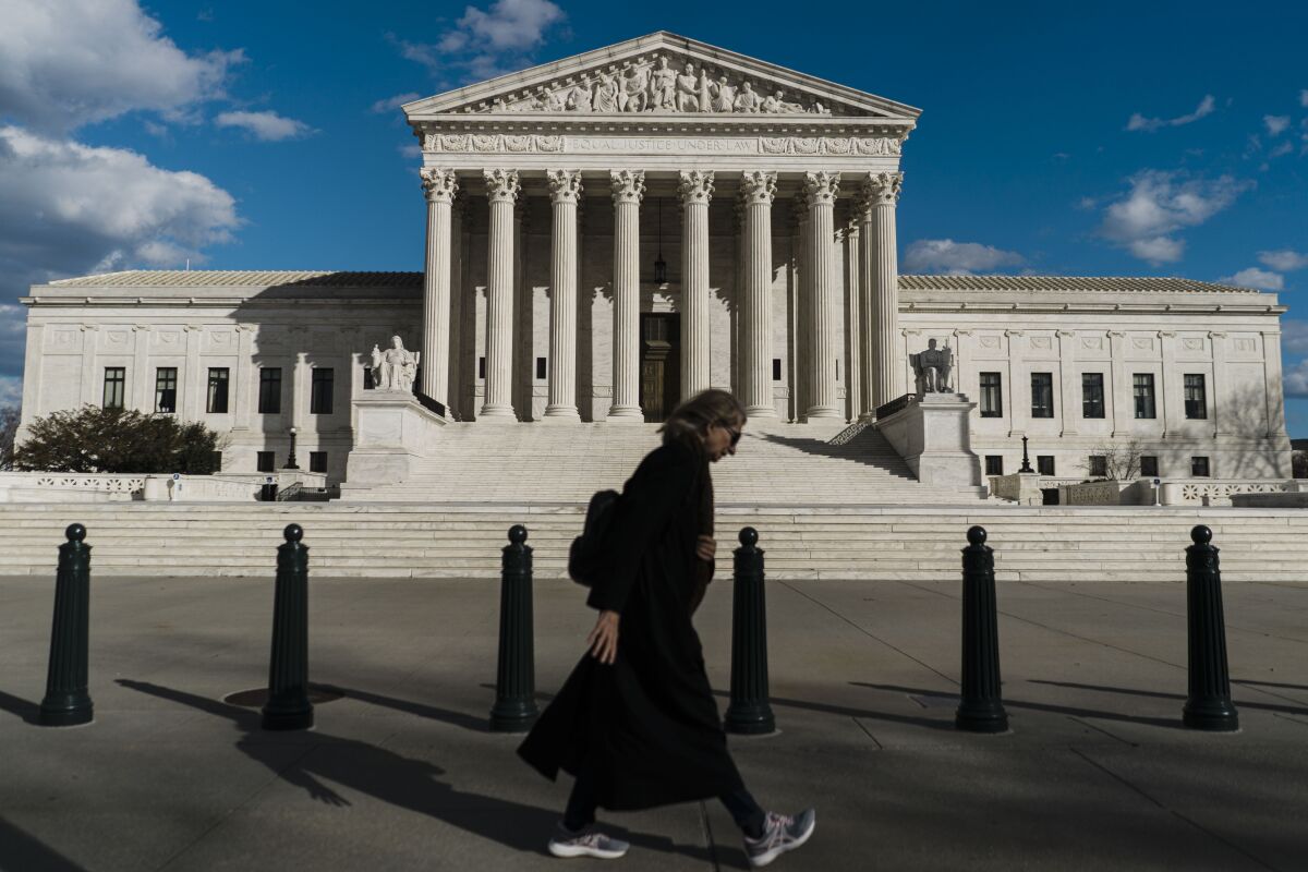 A pedestrian walking in front of the Supreme Court building in Washington
