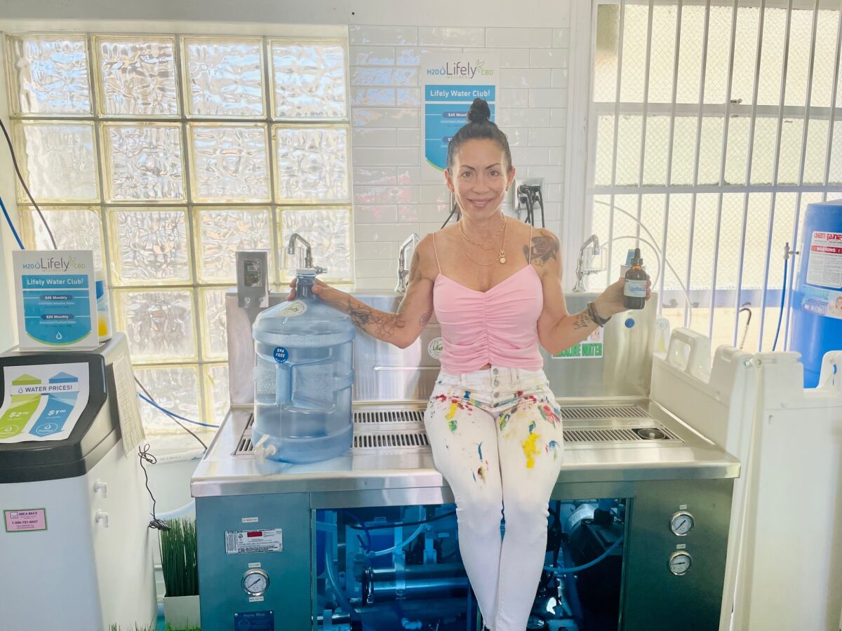Carla Parra sits with the alkaline water creation system in her Lifely Wellness store