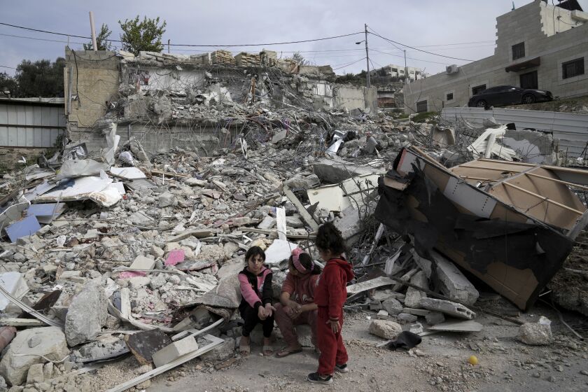 Girls from the Matar family sit near the rubble of their home that housed 11 people before it was demolished by Israeli authorities in the Jabal Mukaber neighborhood of east Jerusalem, Sunday, Jan. 29, 2023. For many Palestinians, the accelerating pace of home demolitions is part of Israel's new ultranationalist government's broader battle for control of east Jerusalem, claimed by the Palestinians as the capital of their future state. Israel says it is simply enforcing building regulations. (AP Photo/Mahmoud Illean)