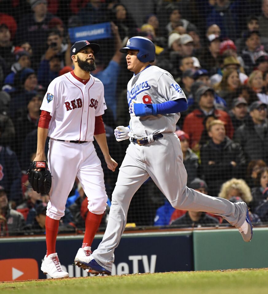 As Red Sox pitcher David Price looks on, Dodgers Manny Machado scores on a single by Yasiel Puig.