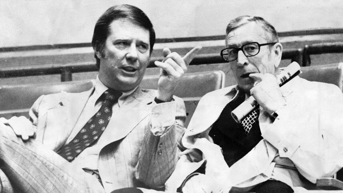 USC's Bob Boyd, left, and UCLA's John Wooden talk before a 1974 game between the two programs.