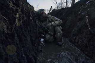 A Ukrainian soldier takes cover in a trench under Russian shelling on the frontline close to Bakhmut, Donetsk region, Ukraine, Sunday, March 5, 2023. (AP Photo/Libkos)