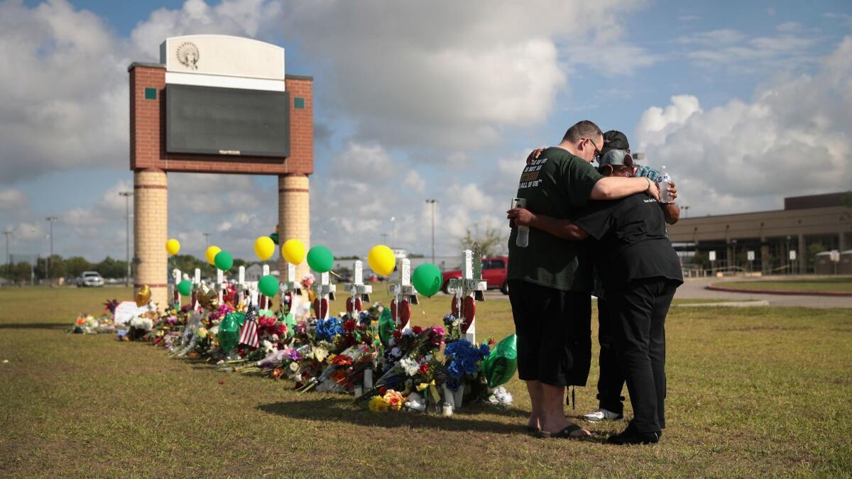 Mourners pray at a memorial in front of Santa Fe High School in Santa Fe, Texas, on May 22.