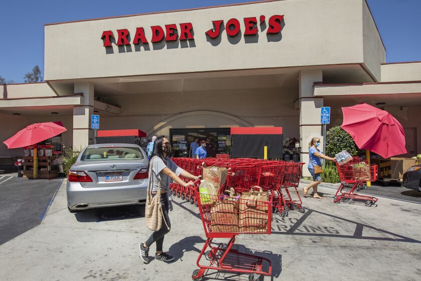 SHERMAN OAKS, CA -JULY 20, 2020: Customers make their way with groceries after shopping at Trader Joe's on Riverside Dr. In Sherman Oaks. Trader Joe's has responded to criticisms about its packaging by announcing that it is in the process of eliminating labels that use ethnic-sounding names intended to be humorous. The offending products bear such labels as Trader Ming's for foods and condiments related to Chinese cuisine, Trader Jose's for Mexican-style products and Trader Giotto's for Italian-themed items. (Mel Melcon / Los Angeles Times)