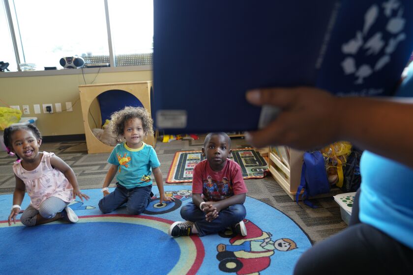 Donna Stephenson, one of the preschool teachers at St. Vincent de Paul Village reads from a story book to preschool children at the Therapeutic Childcare at the St. Vincent de Paul Village in downtown, San Diego. Preschool children left-to-right, Arianna, Xandrix and Jyrese.