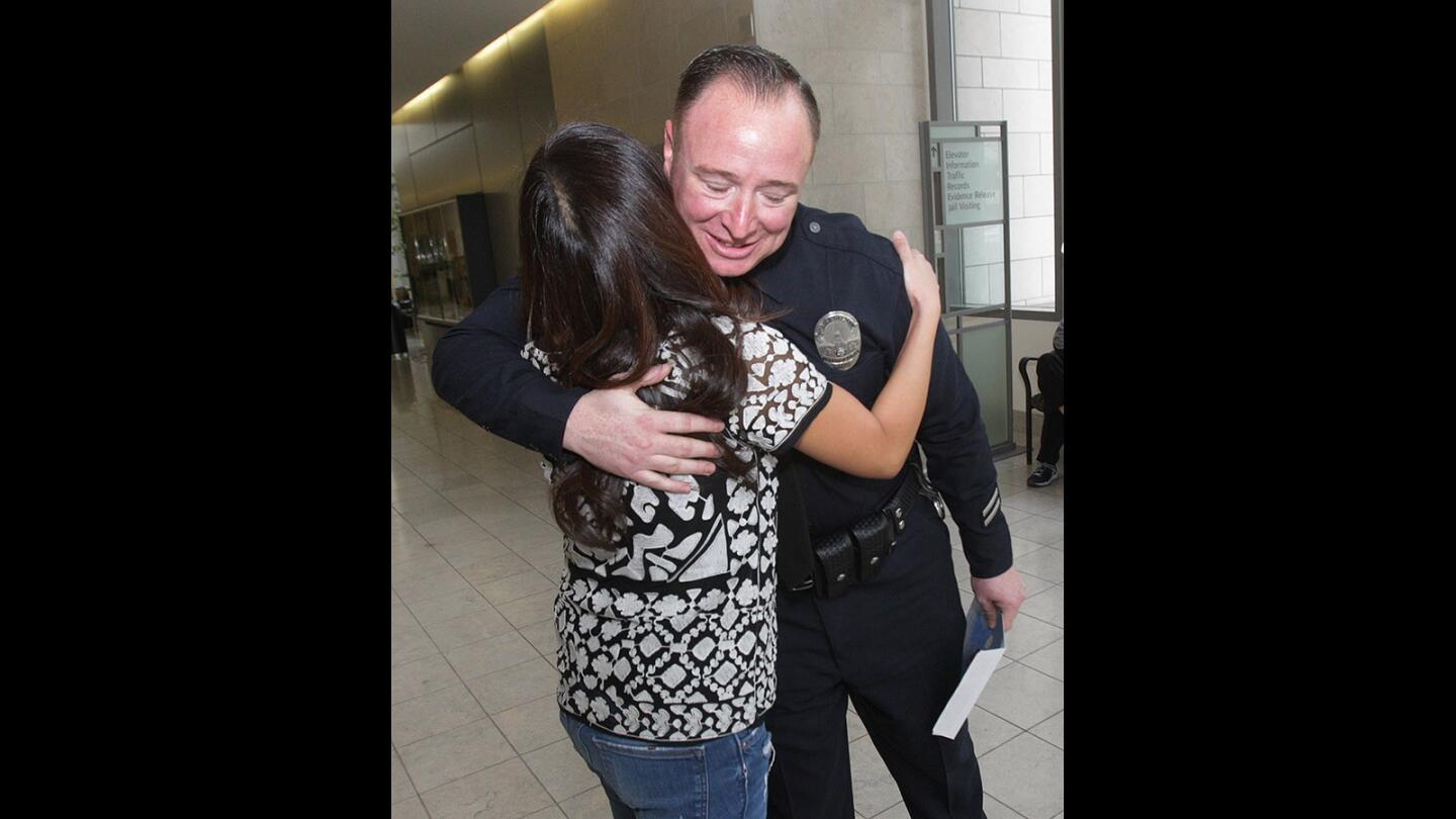 Jennifer Cha of Glendale hugs and thanks Glendale police officer James Colvin at the Glendale Police Department on Thursday, Jan. 22, 2016. Last April, Colvin was the first on the scene to treat then 2-year-old Clayton, who had fallen on his head from 22-feet onto concrete.