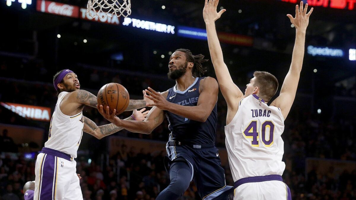 Memphis Grizzlies guard Wayne Selden (7) drives to the basked guarded by Lakers forward Brandon Ingram (14) and center Ivica Zubac (40) at the Staples Center on Sunday.