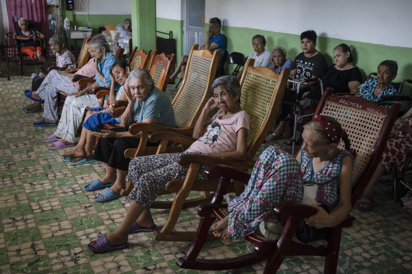 Isabel Ríos, de 73 años (centro), sentada junto a otras residentes de la casa para ancianos Cogra, en Veracruz, México, en medio de las altas temperaturas que azotan el estado, el domingo 16 de junio de 2024. (AP Foto/Félix Márquez)