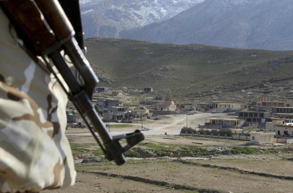 A Yazidi fighter protects the Sharaf al-Deen temple shrine, one of the holiest for the Yazidis, in northern Iraq in January. The Yazidis are a religious minority whom the Islamic State group considers heretics ripe for slaughter.