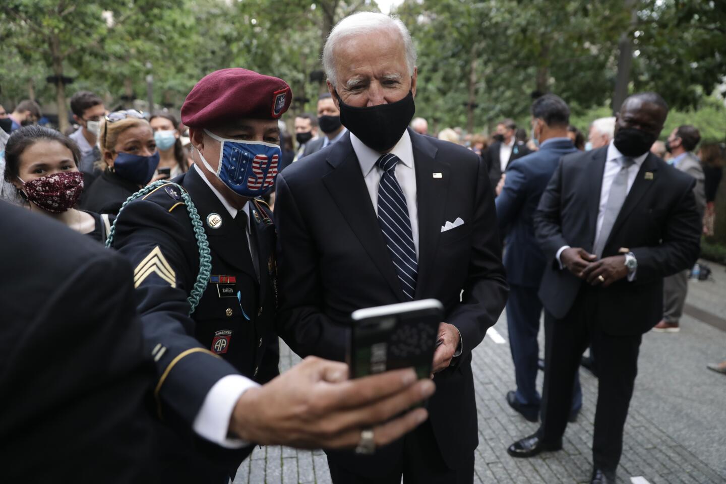 Joe Biden pauses for a photo with a person in uniform at the National September 11 Memorial in New York.