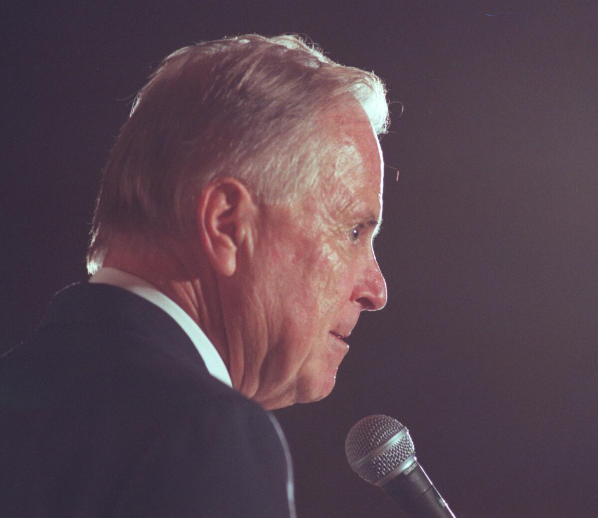 Profile portrait of a man at a microphone 