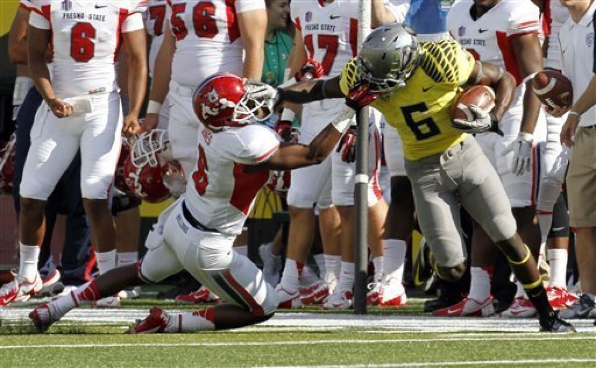 Oregon running back DeAnthony Thomas, right, is pulled down by his face mask by Fresno State defender L.J. Jones during the first half of an NCAA college football game in Eugene, Ore., Saturday, Sept. 8, 2012. Jones was called for a face-mask penalty on the play. (AP Photo/Don Ryan)