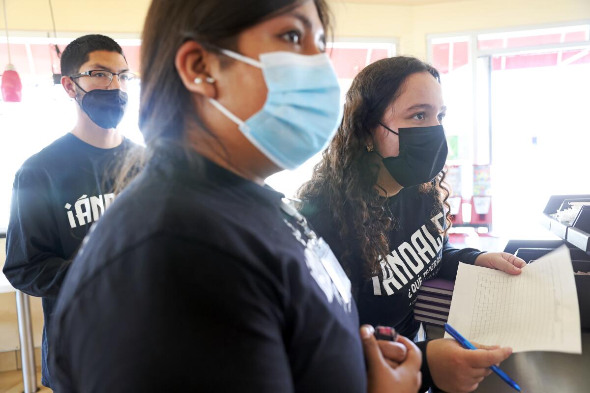 Three people wearing masks