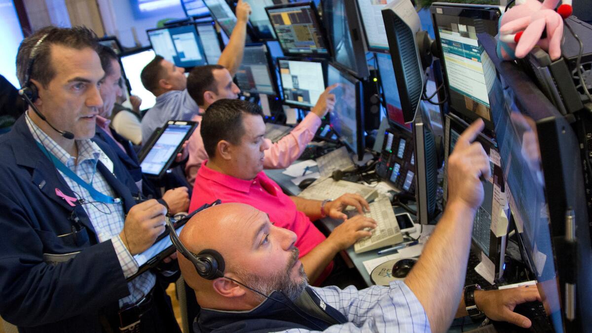 Greg Rowe, left, and Vincent Napolitano, bottom, with Livermore Trading Group monitor stock prices at the New York Stock Exchange on Friday.