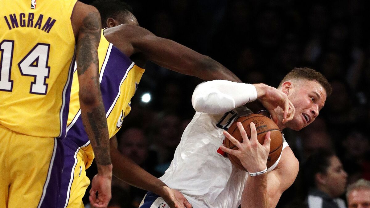 Clippers forward Blake Griffin tries to protect the ball from the reach of Lakers forward Julius Randle during the first half.