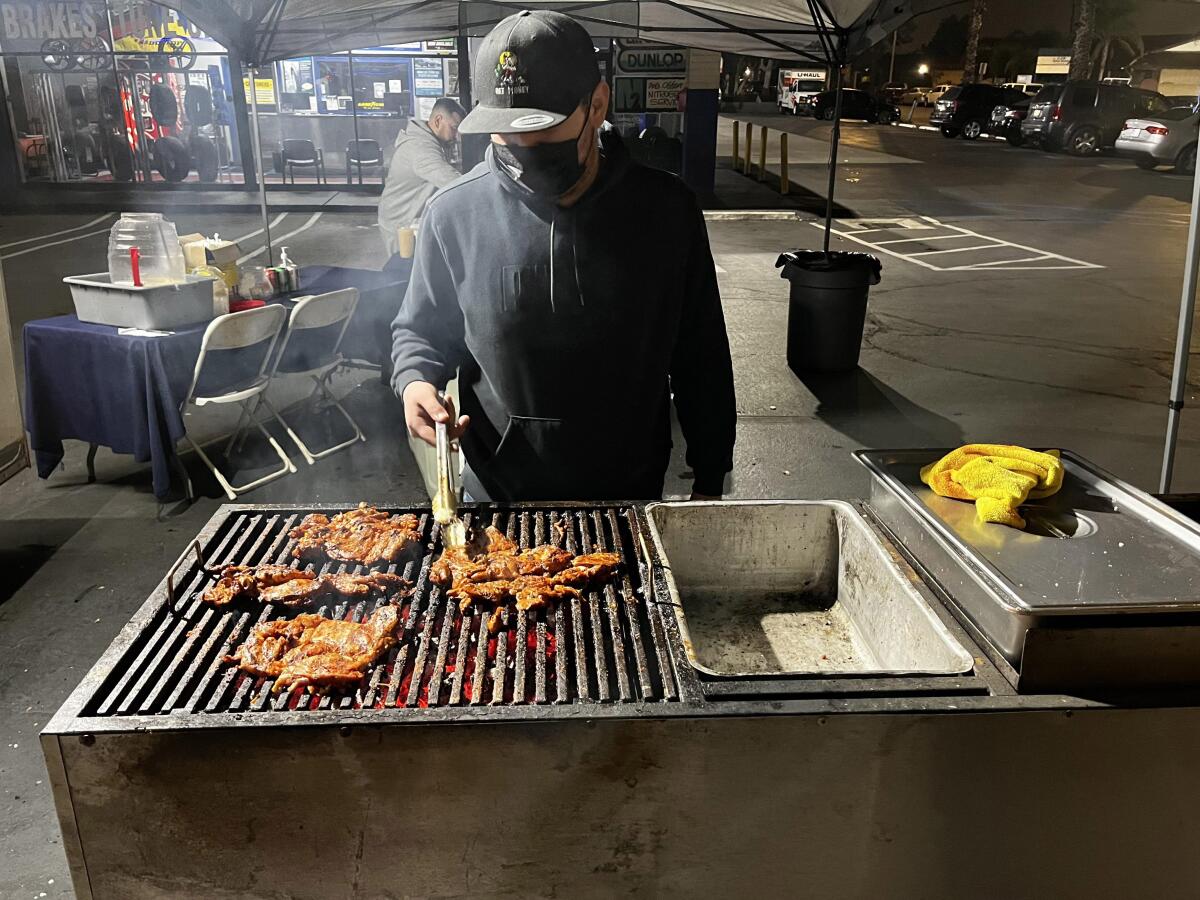 Hector "Guero" Garcia grills carne asada over a charcoal grill at Taquería El Puerto, a permitted taco trailer in Anaheim. 