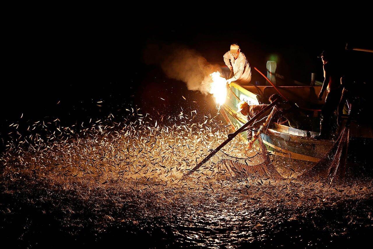 Fishermen use a fire to attract fish on a traditional "sulfuric fire fishing" boat in New Taipei City, Taiwan.
