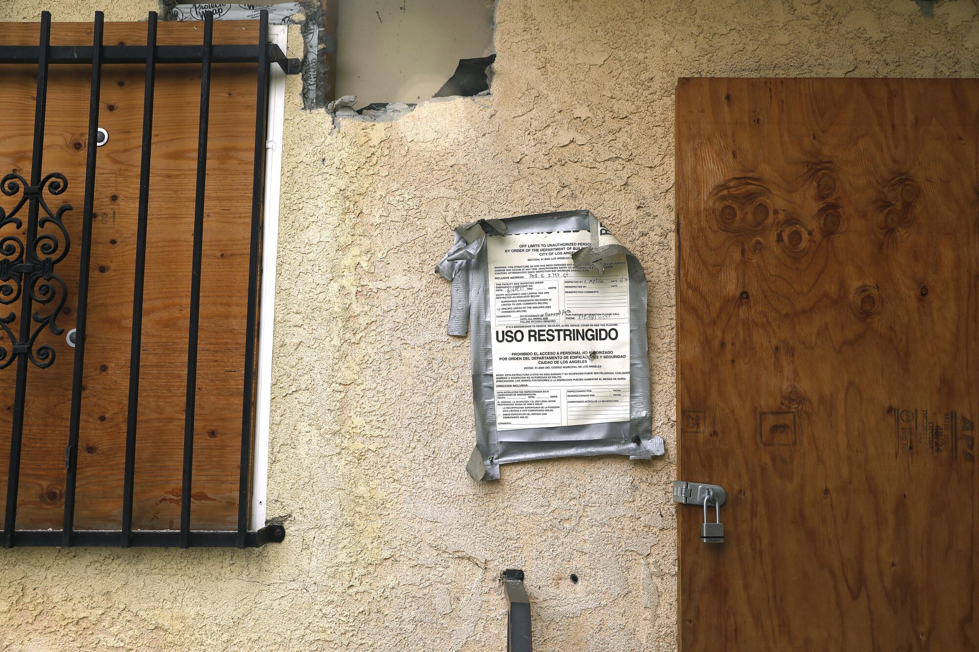 A sign reads 'restricted use' in Spanish on a home on 27th Street in South Los Angeles.