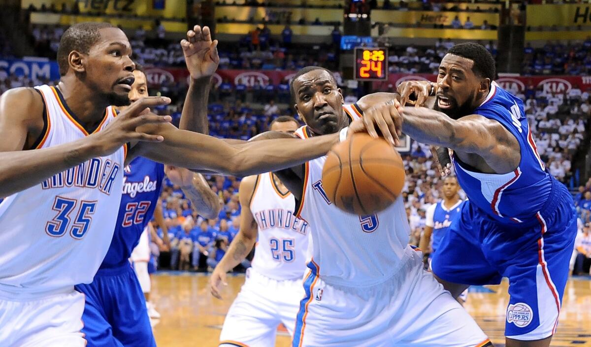 Clippers center DeAndre Jordan, right, tries to get a loose ball away from Thunder center Kendrick Perkins (5) and forward Kevin Durant (35).
