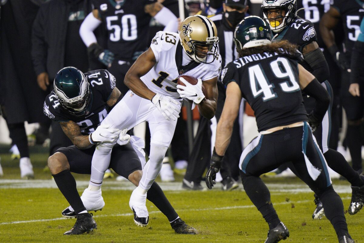 New Orleans Saints' Michael Thomas (13) is tackled by Philadelphia Eagles' Darius Slay (24) during the first half of an NFL football game, Sunday, Dec. 13, 2020, in Philadelphia. (AP Photo/Chris Szagola)