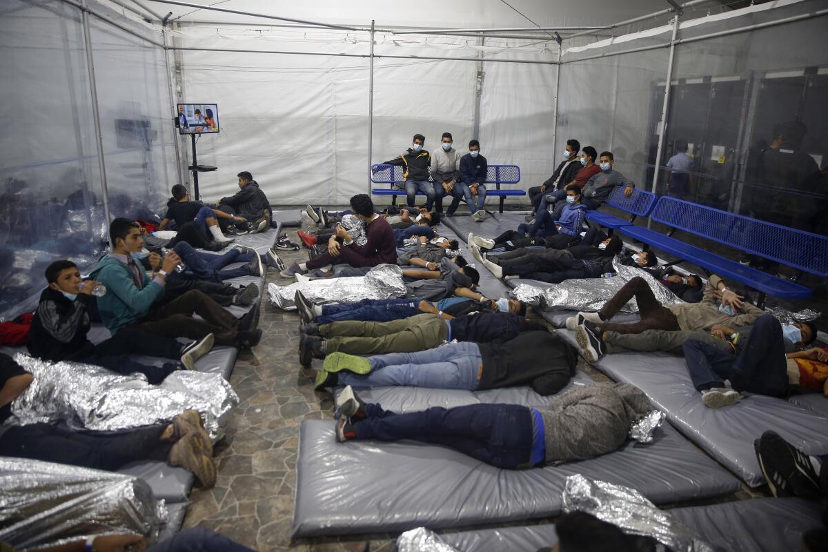 Niños yacen en el interior de un centro de detenciones para menores migrantes no acompañados en Donna, Texas.