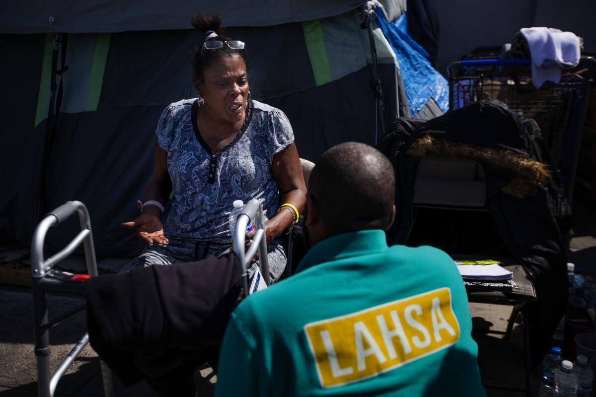 An outreach worker talks with a homeless woman